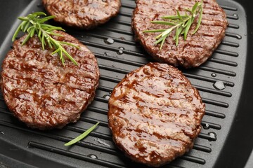 Pan with grilled patties and rosemary, above view