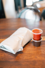 Fish and chips bundle on kitchen table with sauce and gravy
