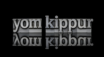 Obraz premium Yom Kippur text in metal letterpress blocks with reflection on black background, perfect for holiday greetings and religious publications
