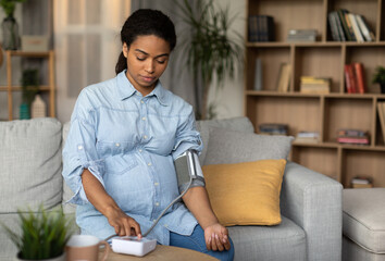 Pregnant African American Lady Measuring Arterial Blood Pressure Having Hypertension Problem...