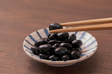 A traditional dish made for Japanese New Year's celebrations. Boiled black beans.正月などに作られる日本の伝統的な料理。黒豆の煮豆。