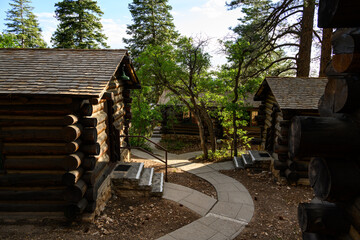 Cement path winding through rustic log cabins in a ponderosa pine forest, peaceful summer vacation retreat on the north rim, Grand Canyon National Park, Arizona
