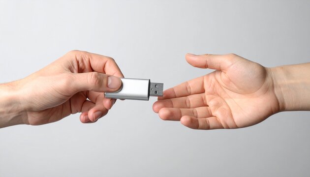 Handing Over Data A Person's Hand Giving a USB Drive to Another Hand for Sharing