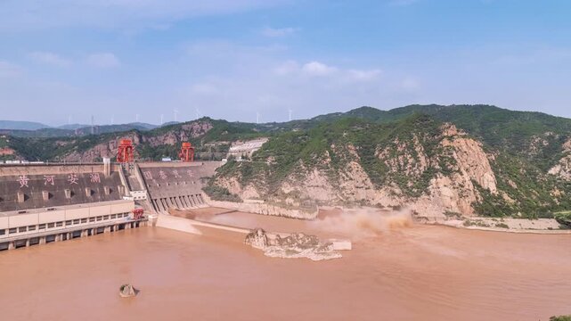 time lapse of the the Sanmenxia Dam on the Yellow River in Henan Province. the massive concrete dam, adorned with Chinese characters (Huanghe Anlan meaning "Yellow River in Peace" and Guotai Min'an me