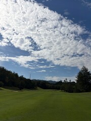 Golf Course Fairway with Dramatic Cloud Formation and Mountain Backdrop