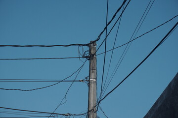 high voltage power lines. utility pole with many wires against a blue sky.