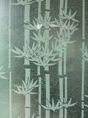 A bamboo forest is depicted on a glass window