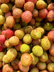 A bunch of green and red fruit with a lot of spots