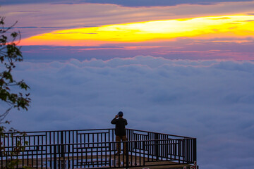 silhouette of a man standing on terrace with sea of mist