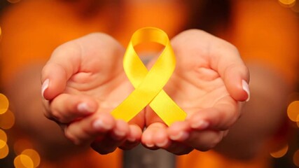 Hands gently holding a bright yellow awareness ribbon symbolizing hope and support for various causes and charities