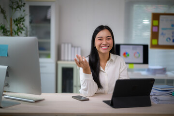 Asian businesswoman smiling in office, working at desk