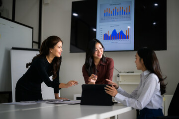 Businesswomen discussing sale performance data in meeting