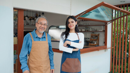 Senior Asian man father and Young Asian woman daughter barista smiling and standing in front of coffee shop, Bakery cafe small business owner concept