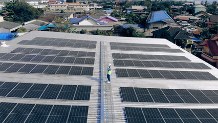 Top view of Engineer man walking to checking solar cell on roof top at industrial factory