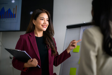 Asian business woman presenting financial data in office meeting