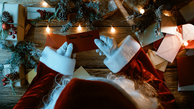Santa Claus reading letters with Christmas wishes