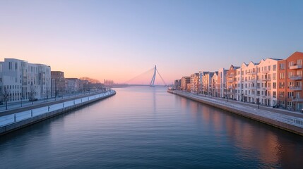 Fototapeta premium Suspension Bridge over River at Sunset Urban Cityscape with Orange and Blue Sky White Buildings and Snow