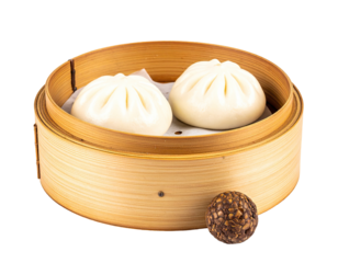 Two steamed buns in a bamboo steamer basket, a dark-colored ball is slightly off-center to the bottom right