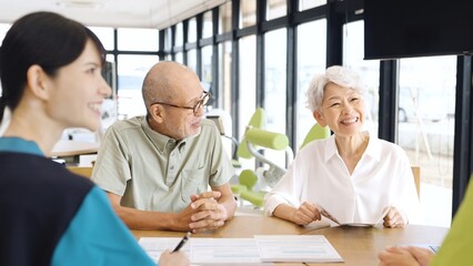 介護施設の説明を受けるアジア人高齢者