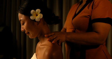 Young Asian woman getting a shoulder massage from the staff in the spa Thai massage