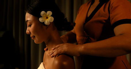 Young Asian woman getting a shoulder massage from the staff in the spa Thai massage