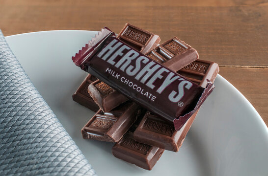 Hershey's chocolate bar on a white plate on a wooden table for marketing or advertising image