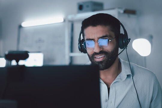 Male IT support specialist wearing  headset and glasses working remotely on a video call from office, focused on customer service, technical assistance, or online consultation. - Powered by Adobe