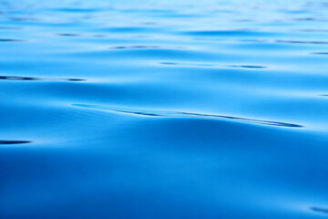 Calm blue water surface with gentle ripples and reflections