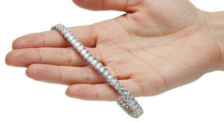 Hand holds a diamond tennis bracelet showcasing its sparkle and design against a white background