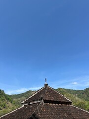 Old Mosque Roof with layered tiles pointing upward into blue sky, showing cultural architecture and heritage design details.