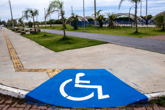 Accessible sidewalk with ramp and signage for people with disabilities (PWD). Illustrates inclusion and accessibility in public spaces.