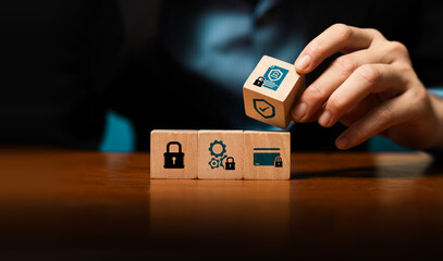 Cybersecurity and data protection concept with businessman hand stacking wooden blocks with lock, shield, ID icons, symbolizing privacy, compliance, secure system, risk management, information safety © Sutthiphong