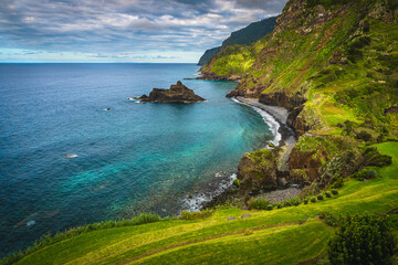 Admirable seaside view with colorful rocks and green steep slopes