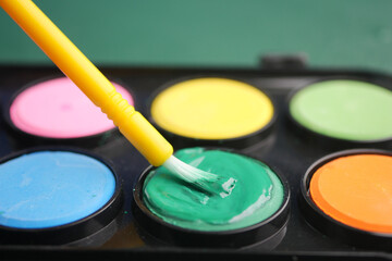 Bright green paint applied with a yellow brush in a set