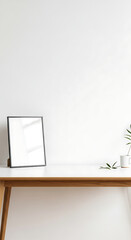 Minimalist Workspace with Blank Picture Frame and Green Plant