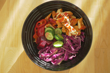 Colorful salad bowl with fresh vegetables and chicken strips