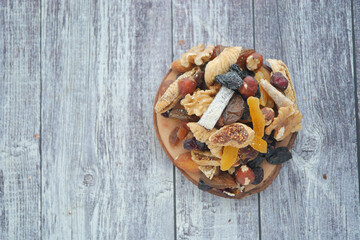 Tasty dried fruits and nuts on a wooden table
