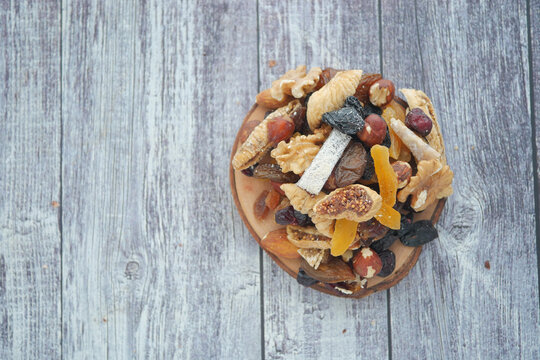 Tasty dried fruits and nuts on a wooden table