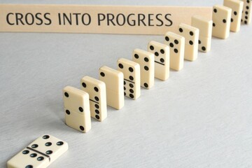 Domino line forming a bridge shape representing progress