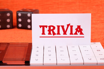TRIVIA word on a white business card on a calculator on an orange background