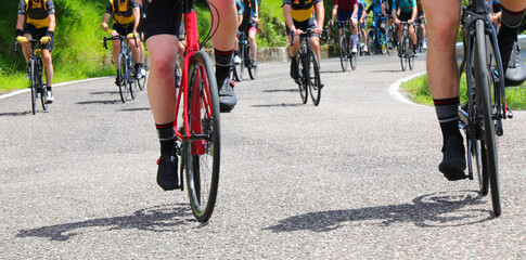 Fototapeta premium wheels of racing bikes as cyclists climb a steep mountain pass during a road race
