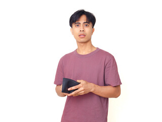 Sad young Asian man with funny expression holding empty wallet, showing frustration and poverty on...