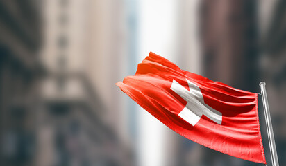 Switzerland national flag waving on street. A beautiful with mast with blur buildings. Switzerland...