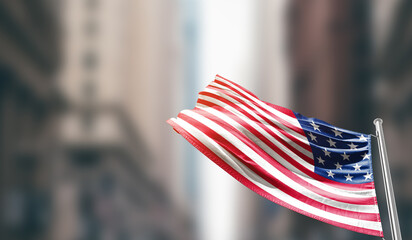 United States national flag waving on street. A beautiful with mast with blur buildings. American...