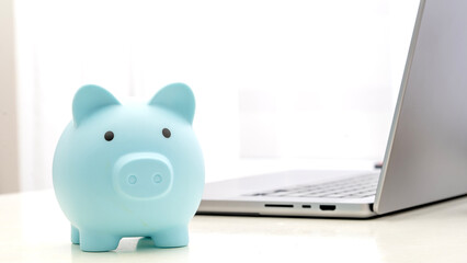 Piggy bank piggy bank on the table by the laptop