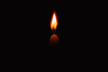 burning candle on black background