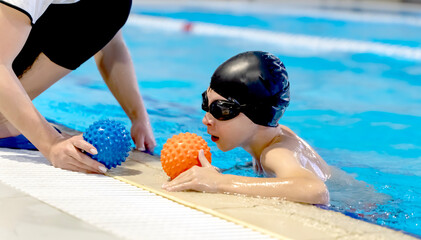 A boy in the pool to learn to swim or swim