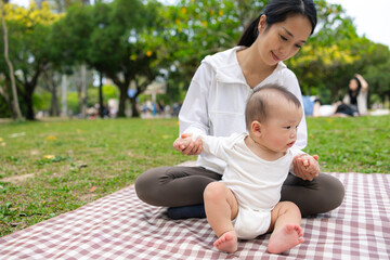 Mother and baby enjoying picnic together at park