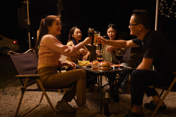 Happy Friends Celebrating Together at Night, Young Asian Group of Friends Having Fun and Toasting Drinks Outdoors, Enjoying a Celebration Concept.