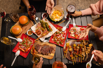 Happy Friends Celebrating Together at Night, Young Asian Group of Friends Having Fun and Toasting Drinks Outdoors, Enjoying a Celebration Concept.